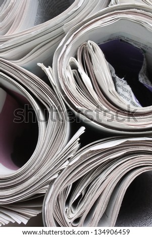 Rolled up newspapers ready for recycling or delivery and photographed from above in black and white
