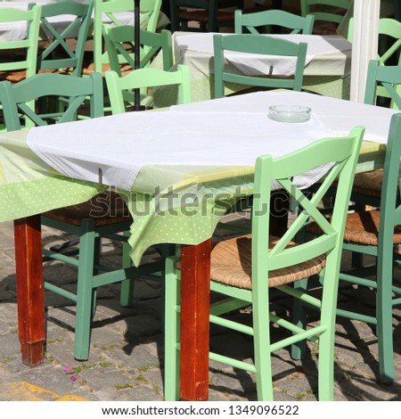 Restaurant tables and green chairs in Athens, Greece