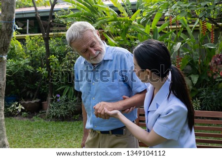 senior man happiness sitting with smiling nurse, takes care and discussion and cheer in the garden at nursing home