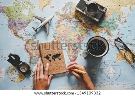 Top view of young woman planning her vacation using world map - Travel  influencer looking for the next travel destination - Concept of adventure, tourism, and traveling people lifestyle Royalty-Free Stock Photo #1349109332