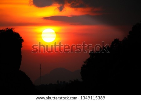 The sun is falling behind the mountain. Silhouette style