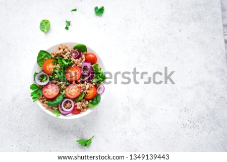 Buckwheat salad with vegatables and greens on white background, copy space. Heathy clean vegan raw food, fresh salad with buckwheat. Royalty-Free Stock Photo #1349139443