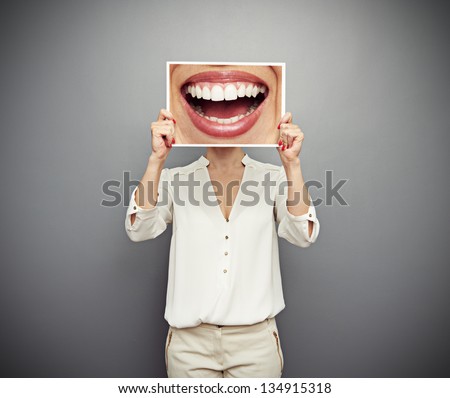 woman holding picture with big smile. concept photo over dark background