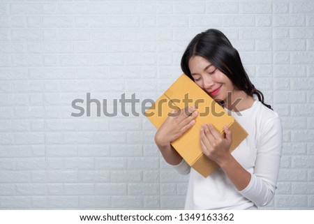Woman holding a brown post box Made gestures with sign language.