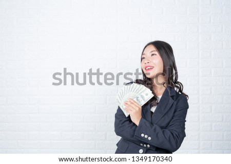 Business woman holding banknote, cash separately, white brick wall Made gestures with sign language.