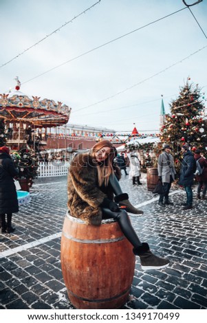 German good-looking young girl enjoying her time in Moscow through winter holiday  on New Year's Fair