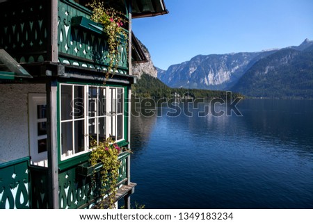 Sunny day on the lake in the Alps. The ancient city of Hallstatt . Tiled roofs, wooden green house and lake and mountain views.