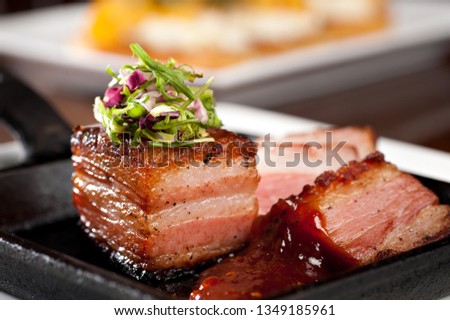 Grilled pork belly with coleslaw and spicy bbq sauce served on a hot skillet

 Royalty-Free Stock Photo #1349185961