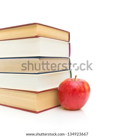 stack of books and a ripe red apple isolated on white background. vertical photo.