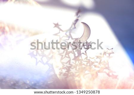 Silver half-moon and stars on white background.