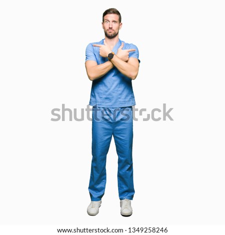 Handsome doctor man wearing medical uniform over isolated background Pointing to both sides with fingers, different direction disagree
