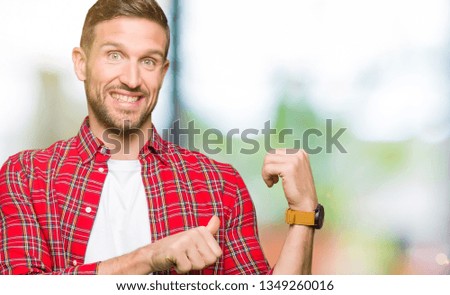Handsome man wearing casual shirt Pointing to the back behind with hand and thumbs up, smiling confident