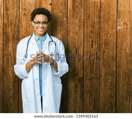 Young african american doctor woman wearing medical coat over isolated background Hands together and fingers crossed smiling relaxed and cheerful. Success and optimistic