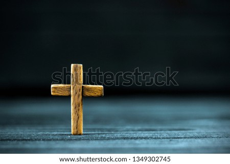 wooden cross on a dark background in the light