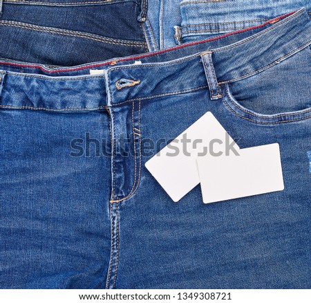 empty paper card lies on blue jeans, full frame