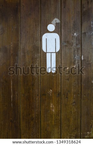 Man rest room sign on grunge wooden door. White painted sign.
