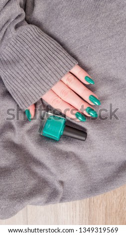 Female hands with long nails with green nail polish