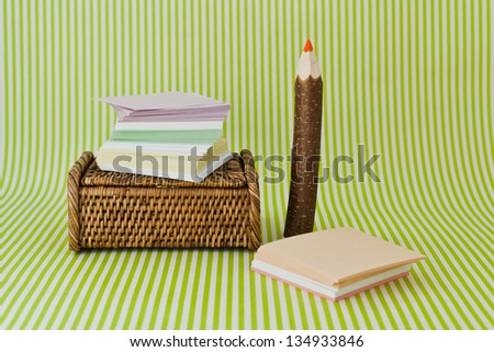 Scratch paper and wooden pencil on a green background