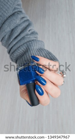 Female hands with long nails with blue nail polish