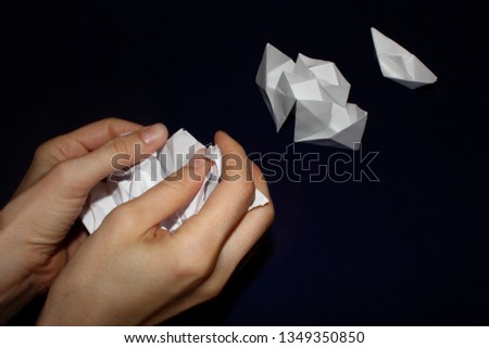 Cultural advance, development, improvement concept with white paper origami boat and steamship on dark background and woman hands making next paper object with enhanced design