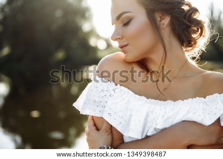 Amazing young girl posing on nature at sunset with pretty smile. Blurred background, bokeh