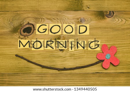 Image of text good morning and flower on wooden table.Toned photo.