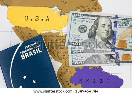 Brazilian passport (Translation "Brazil Republic federal mercosul passport") and one hundred dollar banknotes on world map