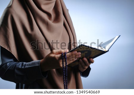 Al Qur'an in hand - holy book of Muslims. -Image Royalty-Free Stock Photo #1349540669