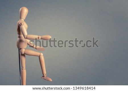 Mannequin made of wood on grey background. Copy space.