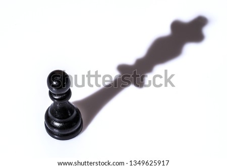 Black chess pawn with queen shadow on white background. Conceptual picture - dreaming and confidence in one's strength.