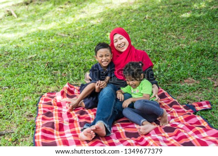 Muslim Family - Mother and Kids. Outdoor Portrait. Happy and cheerful.