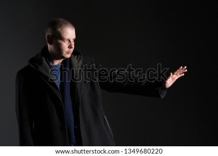 portrait of a man of thirty years in a coat with a hood, studio