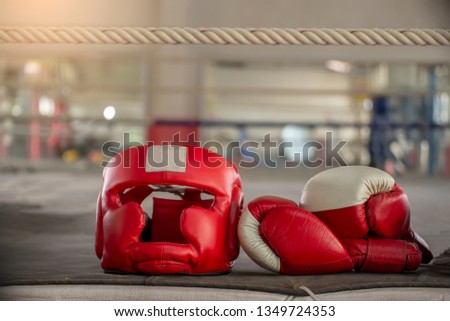 Boxing Headquard and leather mitt glove placed on canvas of ring in camp of training boxer.Equipments for protection during heavy sparring sessions,Used for Muay Thai, Kick Boxing and MMA Training. Royalty-Free Stock Photo #1349724353