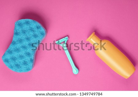 Epilator razor, sponge, bottle shampoo on pink background. Bath concept, minimalism, top view, flat lay