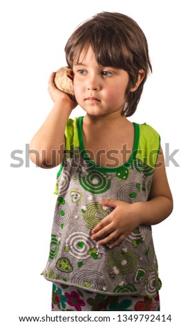 Little girl listens a seashell isolated on white background