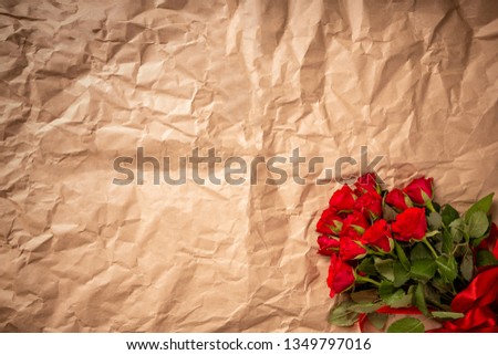 Bouquet of red roses on wrapped paper background