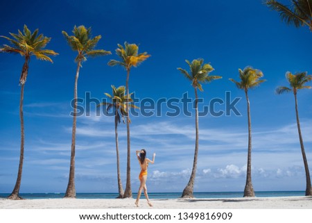 woman in a bathing suit having fun with raised hands on the background of palm trees and oceans Summer vacation relax tropics