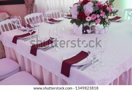 Wedding table decor with red flowers and plates