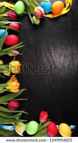 Easter eggs and colorful tulips on rustic table