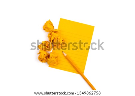 A striped notebook with orange sheets next to which lies a sharpened pencil and six crumpled pieces of paper on white background. Mock up with copy space for text.