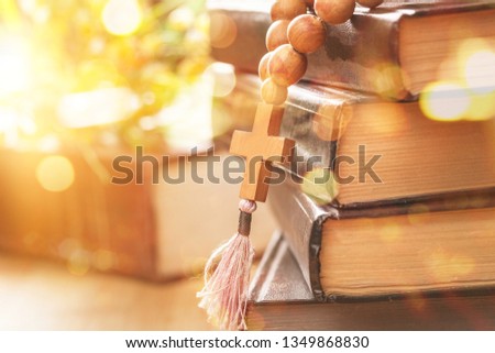 the wooden cross hanged on the bible on top of wood table at church with copy space, can be used for Christian concept or background 
   
