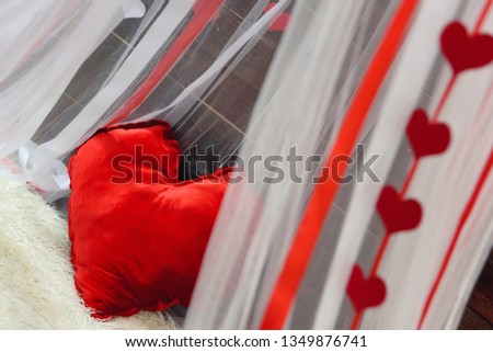 The white canopy in the background of a wooden wall. Romantic photo zone in the photo Studio on Valentine's day. Paper garland in the form of hearts on 14 February.