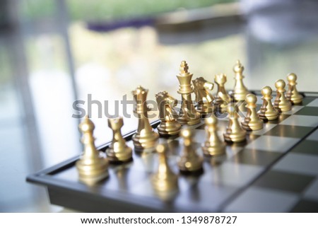 Gold chess game face with the another silver team background .Concept strategy