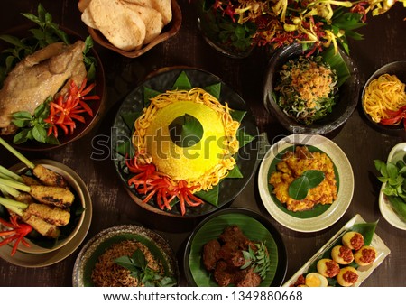 Nasi Tumpeng Nusantara. The elaborate Indonesian rijsttafel of yellow yice with seven side dishes from several regional cuisines in the country. Royalty-Free Stock Photo #1349880668