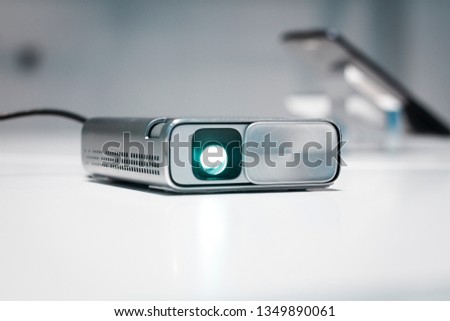 Security and CCTV mini device for any kind of surveillance. Small silver body, high resolution camera sensor, and lens. Futuristic design, spy game. Privacy and personal data issues, pocket projector. Royalty-Free Stock Photo #1349890061