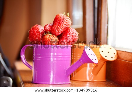 watering cans with strawberries