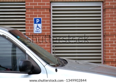 Wheelchair friendly disabled parking only sign next to car. Parking space meant for handicap people in Australia.