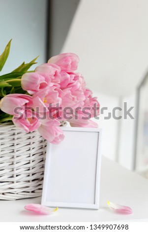 Tulips with blank picture frame on white marble