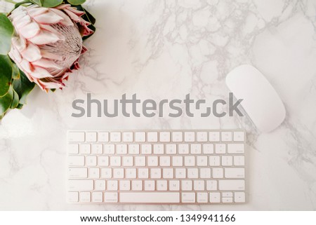 King protea, keyboard & mouse on marble desktop, top view, flat lay.  Home office workspace.