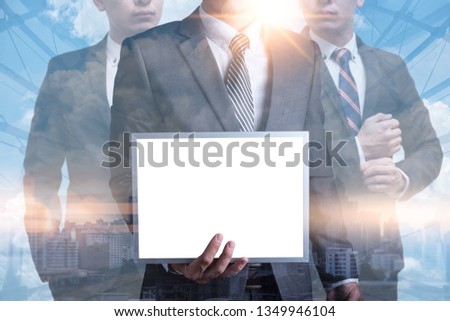 the abstract image of a businessman showing a mock-up whiteboard and cityscape image is the backdrop. the concept of mock-up, business, advertising and message.